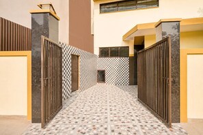 Um caminho estreito com piso de azulejos que leva a um portão.