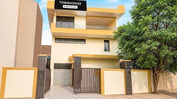 A modern townhouse with a sign indicating it is serviced by OYO.
