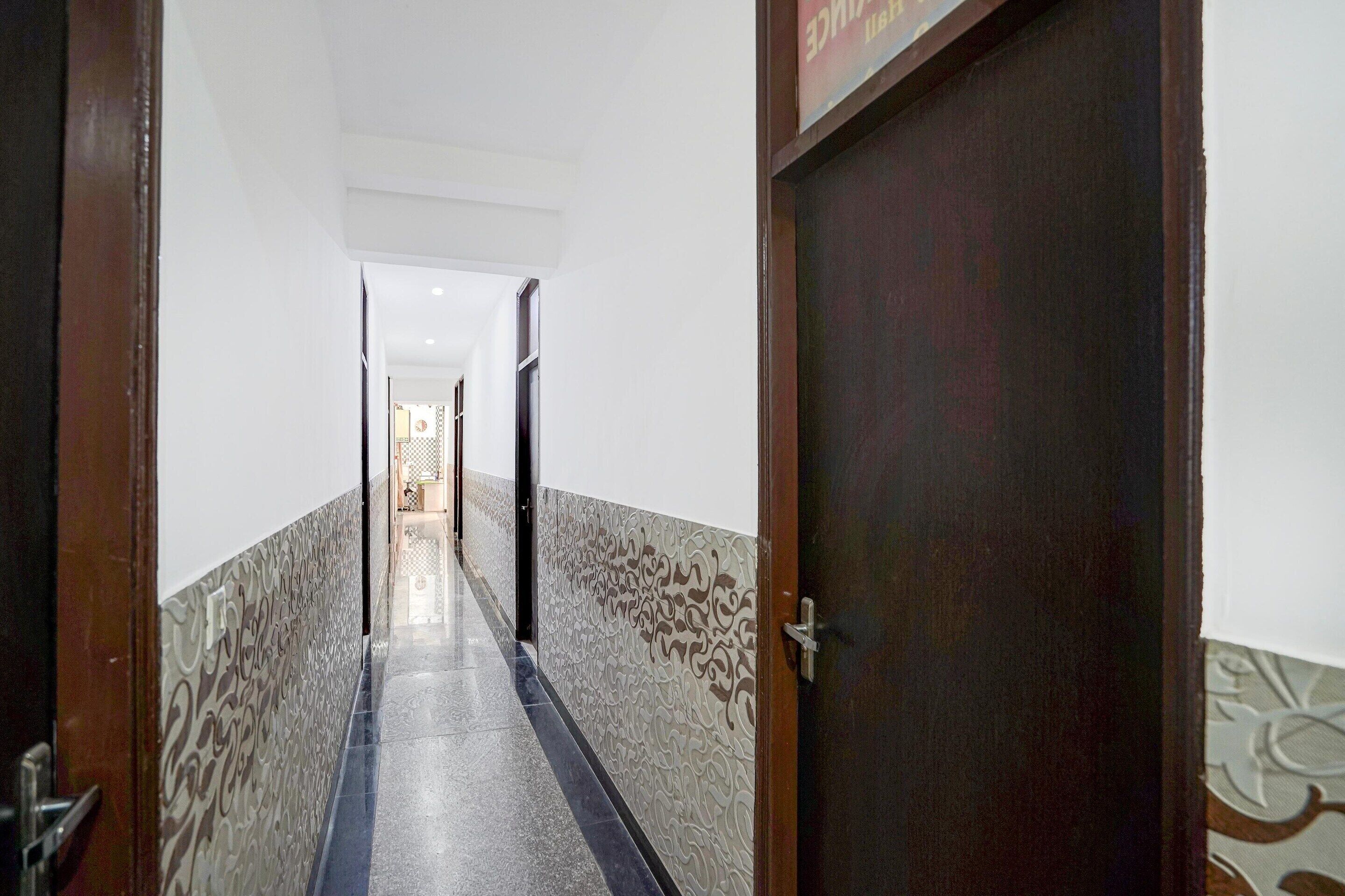 A hallway with patterned walls and a door on the right.