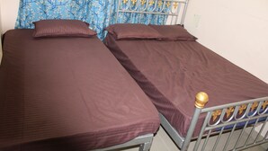 Ein Doppelbett mit Metallgestell und einem Kopfende mit dekorativen Elementen.
