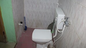 Ein Badezimmer mit Toilette, einem Mop und einem Eimer.