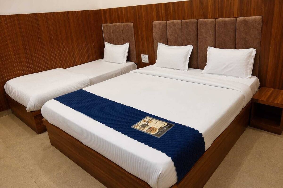 A double bed with a wooden headboard and two single beds.