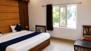 Une chambre à coucher avec un lit, une table de chevet et une fenêtre avec des rideaux.