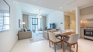 Een moderne woonkamer met een eethoek, een keuken en een groot raam.