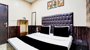 A hotel room with a bed, a bedside table with a phone, a wardrobe, and a mirror. - Saver Double Hotel R1 Inn (Jalandhar)