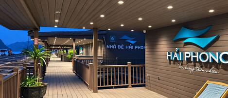 Un espace extérieur abrité doté d’une terrasse en bois, d’un bar et d’un coin salon avec des fauteuils confortables.