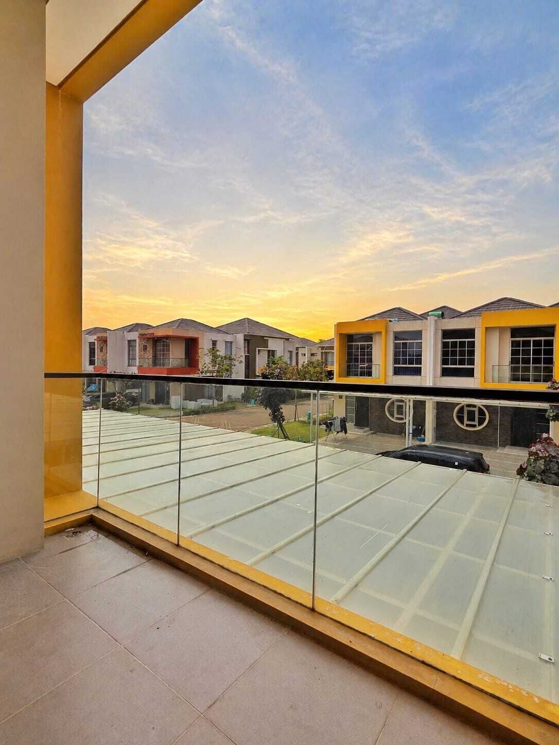 Uma varanda com vista para edifícios residenciais e um céu limpo.
