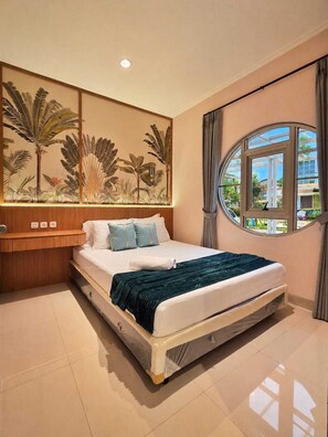 A bedroom with a bed, a nightstand, a wall-mounted artwork, a window, and a view of the outside. - Lavele By SanLiving - 3BR - PIK2 (Banten)