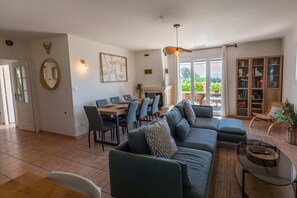 Ein Wohnzimmer mit einer Couch, einem Esstisch, Stühlen und einem Kamin.