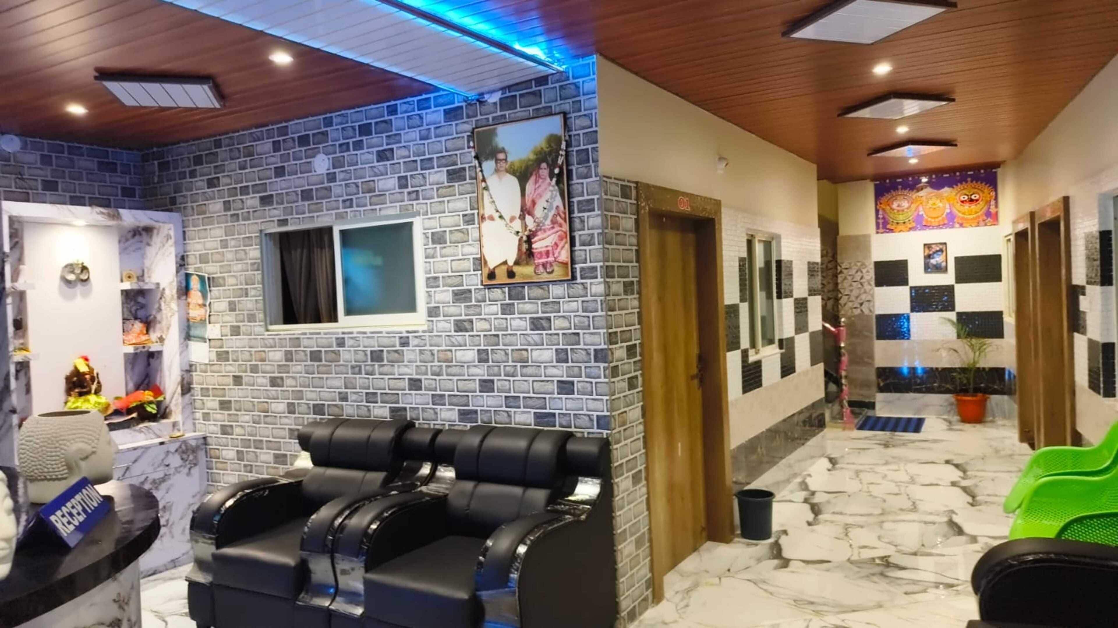 Zona de spa con sillones de masaje, una recepción y una pared decorativa con un cuadro.
