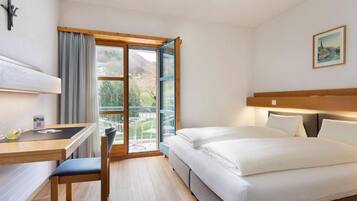 Una habitación de hotel con una cama, un escritorio y una silla.