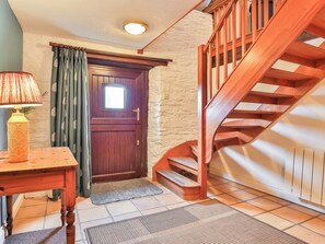 A wooden staircase with a handrail, a wooden door with a window, and a table with a lamp. - 2 bedroom accommodation in Dulverton (Dulverton)