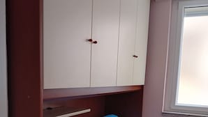 A room with a blue sofa, a white wardrobe, and a window with blinds. - Vacation rental with breathtaking ocean views, two minutes from the beaches (Finale Ligure)