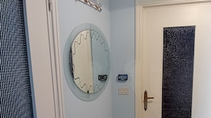A hallway with a door, a wall-mounted mirror, a thermostat, and a welcome sign. - Vacation rental with breathtaking ocean views, two minutes from the beaches (Finale Ligure)