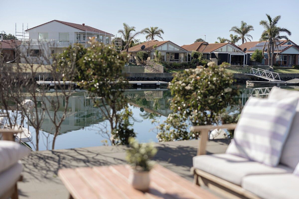 A residential area with houses, a swimming pool, and a wooden deck with a sofa.