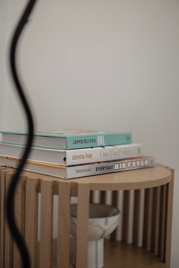 A stack of books on a wooden table.