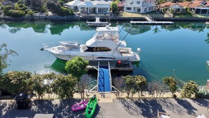 Ein Yachthafen mit einer festgemachteten Yacht, einem Kajak und einer Terrasse mit Gartenmöbeln.