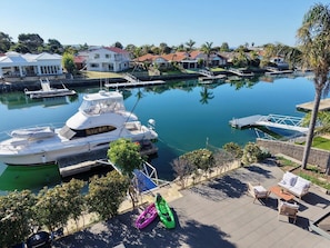 Un port de plaisance avec des bateaux amarrés, un petit quai et un espace extérieur aménagé avec du mobilier de jardin.