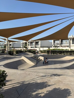 Ein Skatepark mit Rampen und einem schattigen Bereich.