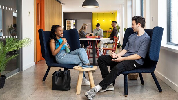 En modern inredning med sittplatser, ett litet bord och en krukväxt.