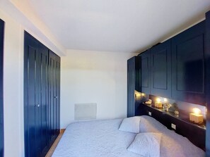 Una camera da letto con un letto, mobili scuri e un comodino con una lampada.