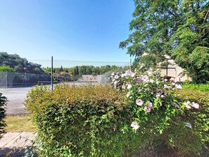 A fenced outdoor area with a variety of plants and flowers, including pink blossoms. - Tennis Résidence by Interhome (Saint Cyprien)