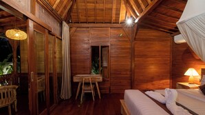 A wooden room with a bed, a table, and a chair. - Pondok Langkih Pool Villa (Gianyar)