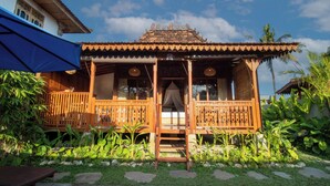 A traditional wooden house with a tiled roof, a wooden porch, and a small pool in the foreground. - Pondok Langkih Pool Villa (Gianyar)