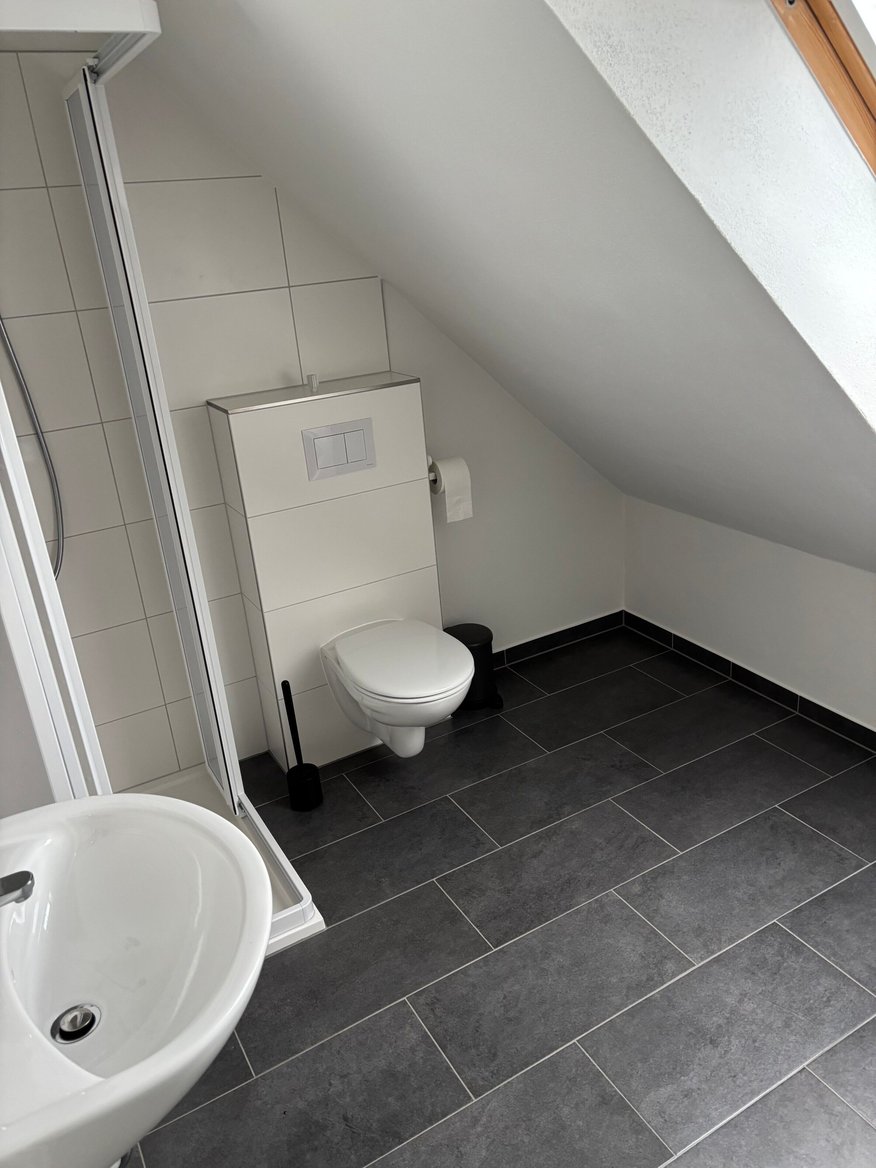 Et moderne badeværelse med toilet, bidet og håndvask.