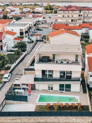 A modern two-story residential building with a rooftop pool and outdoor seating area. - Villa Aura Vir (Vir)