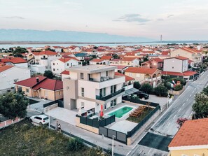A residential area with modern houses, a swimming pool, and a road. - Villa Aura Vir (Vir)
