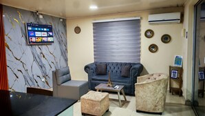 A modern living room with a blue sofa, a coffee table, and a marble wall. - LPW STORE SARIE BAY No. 01 (san Andrés islas, colombia)