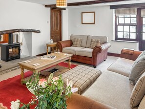 A cozy living room with a sofa, a coffee table, and a fireplace. - 3 bedroom accommodation in Dent (Dent)