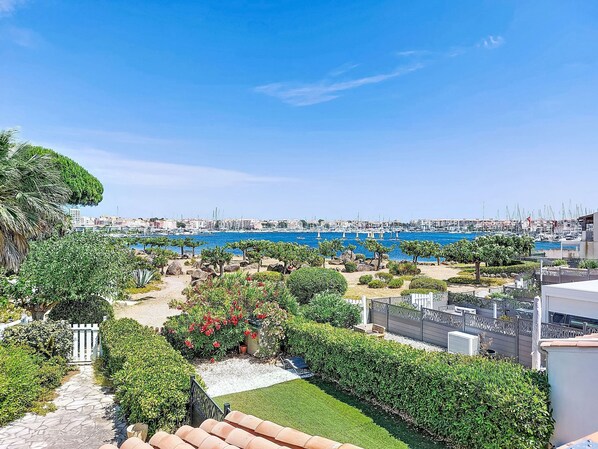 A coastal view with a marina, greenery, and a clear sky. - L'île des Marinas by Interhome (Cap d'Agde)