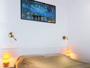 A hotel room with a bed, two wall-mounted lamps, and a painting of a night scene. - L'île des Marinas by Interhome (Cap d'Agde)