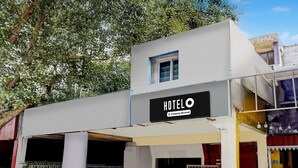 A building with a sign that reads 'HOTEL' and 'Company-Serviced.' There are two visible entrances with metal gates. - Classic Vishnu's Galaxy Rooms (Chennai)