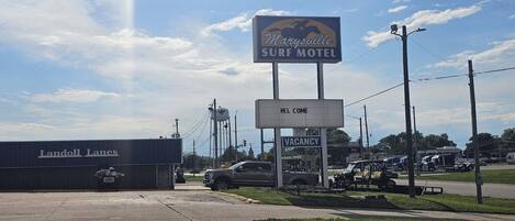 Señal de motel con un mensaje de bienvenida y aviso de habitaciones disponibles.