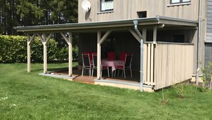 A covered outdoor seating area with a table and chairs.