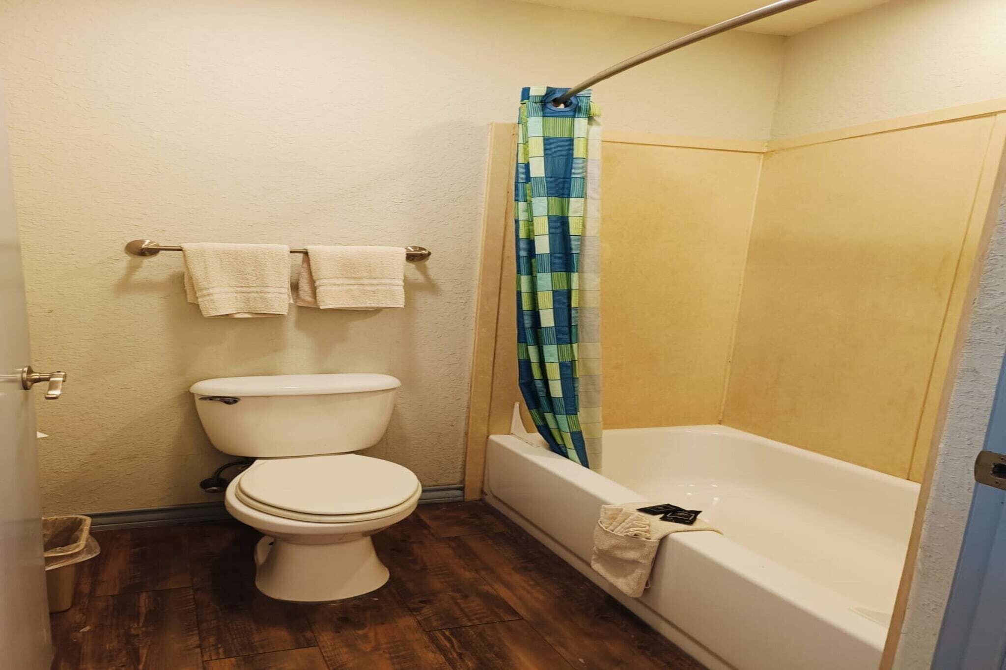 A bathroom with a toilet, a bathtub, and a shower curtain.