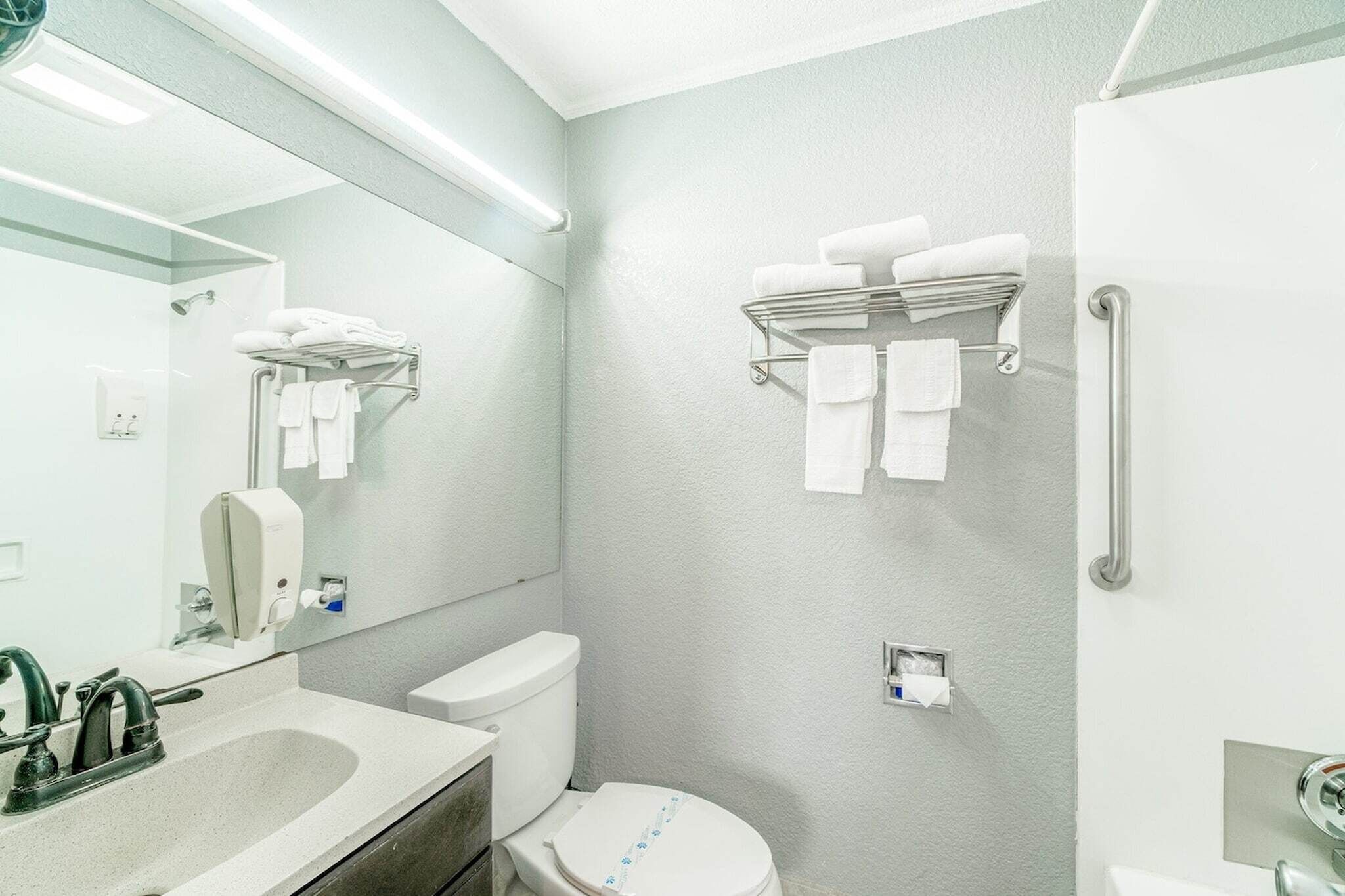 Uma casa de banho moderna com lavatório, sanita e barra para toalhas.