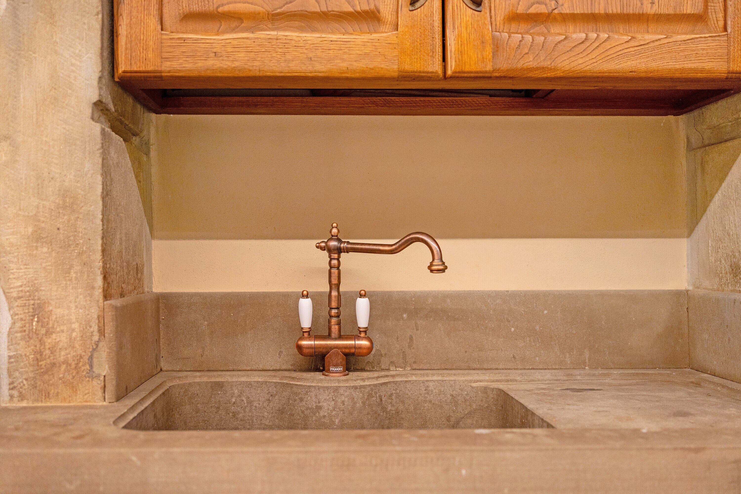 A bathroom with a wooden cabinet above a sink.