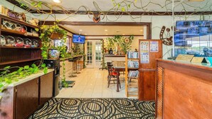 A hotel lobby with a reception desk, a television, and various plants. - Accessible|2 Queen Beds|Nsmk (Snyder TX)