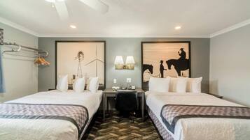 A hotel room with two beds, a desk, a chair, a lamp, and a wind turbine artwork on the wall.