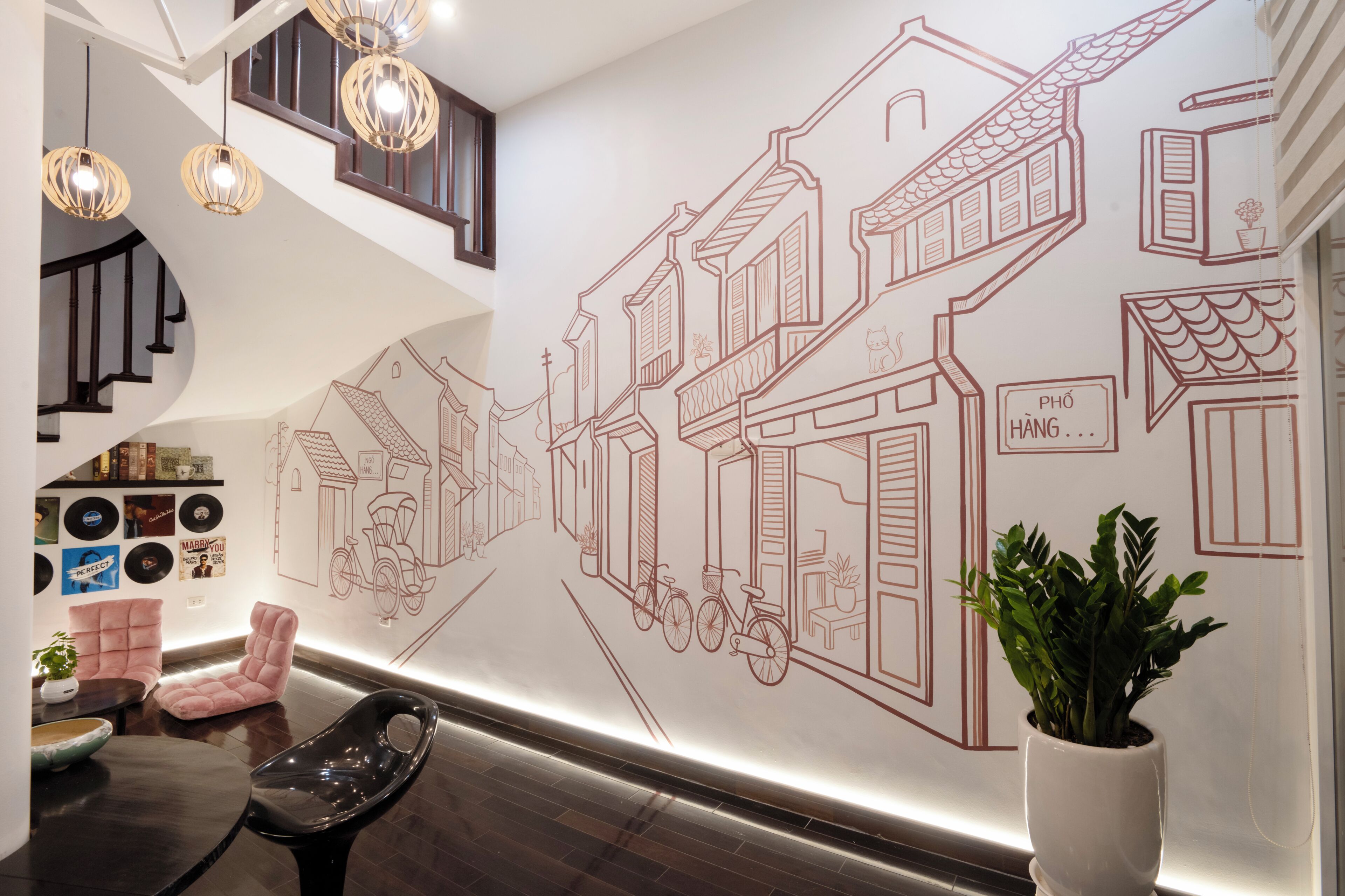 Un intérieur moderne avec un escalier, des œuvres d’art murales et un espace salon.
