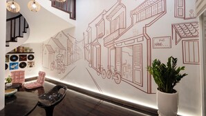 Et moderne interiør med trappe, vægkunst og siddeområde.