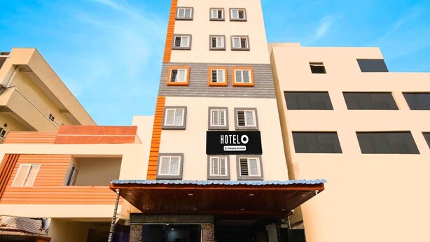A hotel building with a sign reading 'HOTEL' and 'Company Serviced.' - Super Hotel O Gachibowli Near ISB (Hyderabad)