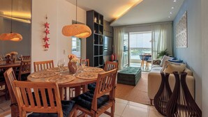 Ein modernes Wohnzimmer mit Essbereich, einer Bücherwand und einem Sofa.
