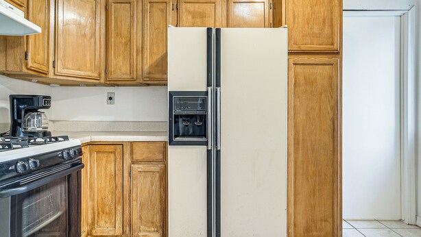 Una cocina con gabinetes de madera, un refrigerador de acero inoxidable, una estufa y un microondas.