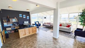 A spacious living area with a kitchen, large windows, and a view of the outdoors.