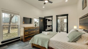 A bedroom with a bed, a dresser, a TV, and a view of the outdoors. - < 1 Mi to Lake Somerville! Dual-Unit Family Base (Somerville)